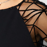 Elegante vestido negro con mangas de malla y corte holgado para un look sofisticado y cómodo