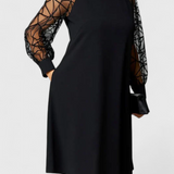 Elegante vestido negro con mangas de malla y corte holgado para un look sofisticado y cómodo