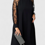 Elegante vestido negro con mangas de malla y corte holgado para un look sofisticado y cómodo