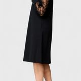 Elegante vestido negro con mangas de malla y corte holgado para un look sofisticado y cómodo