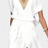 Elegante vestido blanco Effie con escote cruzado, detalle calado y divertida abertura frontal